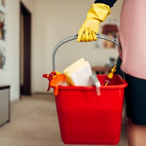 Housemaid hands in gloves holds cleaning equipment
